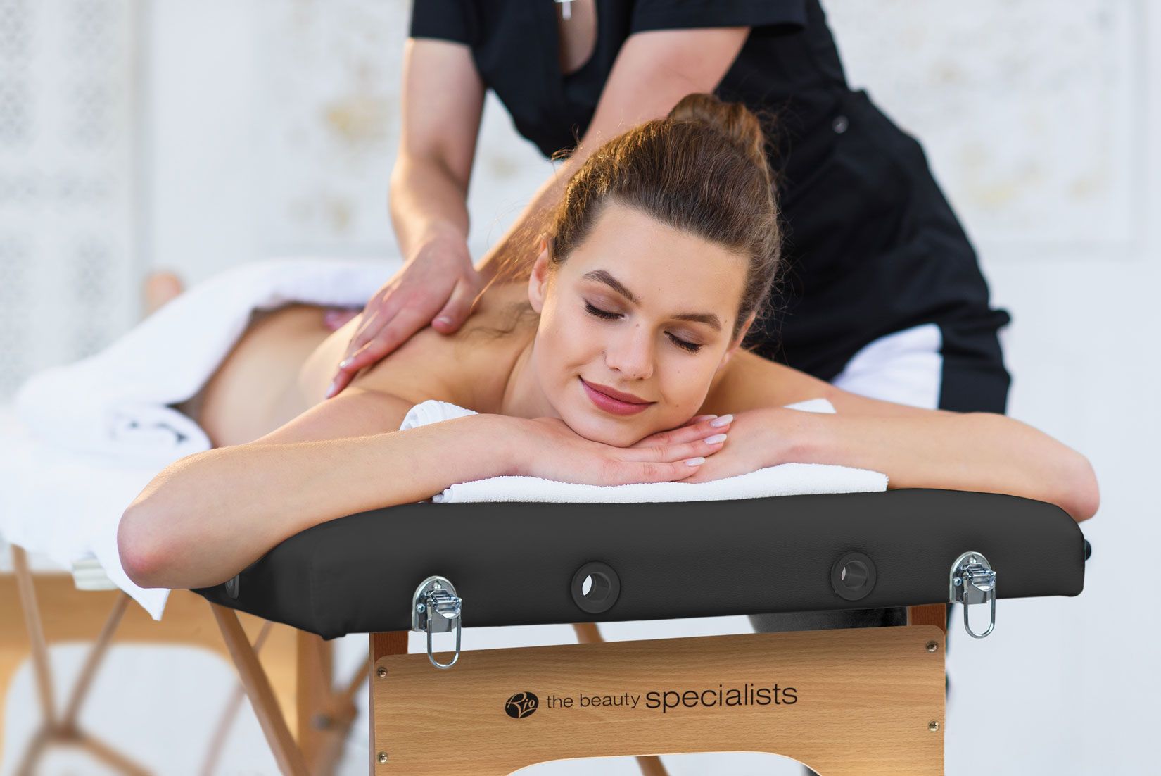 Women receiving massage on the Rio massage table in a professional setting