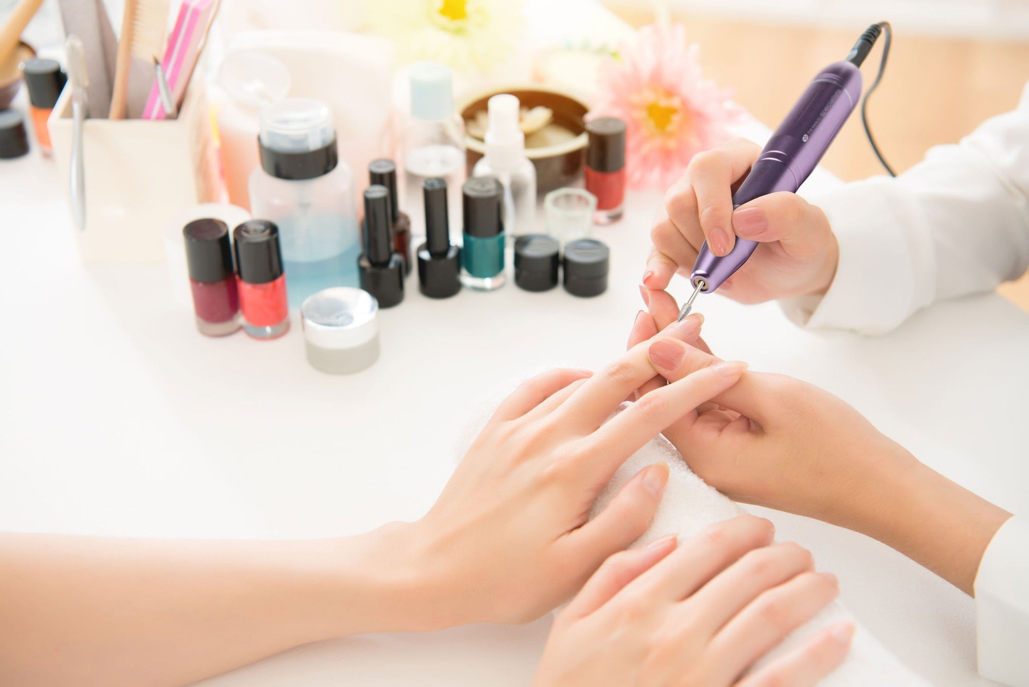 professional nail file being used in nail salon by nail technician to file ladies nails 